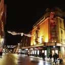 Fachada iluminada del New Theatre Oxford por la noche