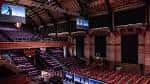 Interior del auditorio con butacas rojas y escenario bajo techo abovedado