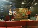 Actuación en el Corpus Playroom con decorado temático y público sentado