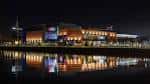 Vista nocturna del The O2 Belfast con reflejos en el agua