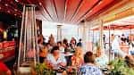 Terraza exterior de 2Taps Winebar con clientes disfrutando en mesas al aire libre