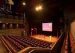 Sala de eventos con escenario y butacas dispuestas para espectáculo