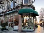 Fachada exterior de The Ivy Belfast Brasserie con toldo verde y arquitectura clásica