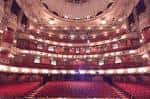 Interior del auditorio vacío con butacas rojas y balcones ornamentados