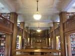Interior de la biblioteca de St Hilda's College con estanterías de madera y iluminación clásica