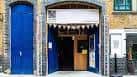 Fachada exterior del Arcola Theatre con puerta azul y detalles arquitectónicos