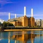 Vista exterior del Battersea Power Station con sus chimeneas icónicas reflejadas en el río Támesis