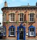 Fachada del pub The Pack Horse con detalles arquitectónicos victorianos y ventanas azules