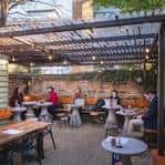 Terraza exterior cubierta con pérgola y ambiente relajado al aire libre