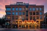 Fachada iluminada de Aethos Hotel al atardecer