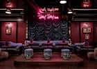 Sala privada de karaoke con decoración en tonos rojos y neón