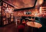 Área lounge interior con paredes decoradas y mesas para eventos