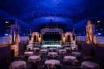 Interior del Granada Theater configurado para eventos con mesas redondas y escenario iluminado