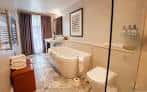 Baño de lujo con bañera independiente y decoración elegante