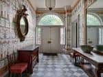Interior elegante del salón principal con suelo de baldosas geométricas y decoración clásica