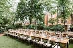 Ceremonia al aire libre en el jardín del Hill-Physick House con mesas decoradas para evento