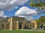 Vista exterior del edificio principal de la Galería Dulwich Picture Gallery con cielo azul y nubes