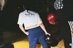 Persona lanzando una bola de bolos en la pista
