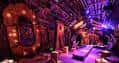 Espacio interior decorado con luces de colores y mobiliario para eventos nocturnos