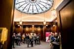 Interior del vestíbulo principal con cúpula de cristal y asistentes reunidos