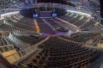 Vista panorámica del interior de la arena con gradas y escenario preparado para evento