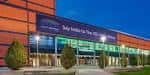 Fachada exterior del SSE Arena Belfast al atardecer con iluminación destacada