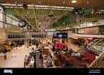 Interior amplio del centro comercial con múltiples niveles, tiendas y zonas de descanso