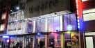 Fachada nocturna del Soho Theatre iluminada con luces de neón y ambiente urbano