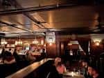 Interior del bar con ambiente acogedor y clientes disfrutando