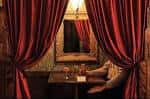 Sala privada con cortinas rojas y mesa para dos