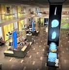 Área de exposición desde una perspectiva elevada, mostrando paneles luminosos y mobiliario moderno