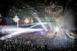 Interior del venue durante un concierto con luces de escenario y multitud de asistentes