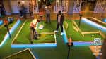 Personas jugando al mini golf en un recorrido iluminado con luces neón