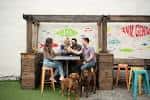 Grupo de personas disfrutando en el área exterior del cervecería
