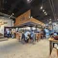 Ambiente nocturno en la terraza del Other Half Brewing con luces de fiesta y asistentes