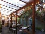 Terraza cubierta con iluminación cálida y ambiente acogedor para eventos