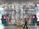Niño interactuando con una gran instalación de tubos transparentes en el Science Oxford Centre