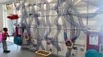 Vista amplia de la exhibición de tubos curvos con niños jugando y explorando