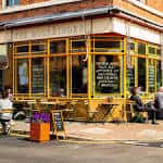 Fachada exterior de The Bookbinder con mesas al aire libre