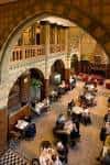 Interior del vestíbulo principal con arcos de piedra y mesas dispuestas para eventos o recepciones