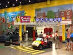 Área interactiva del museo con niños jugando en vehículos pequeños