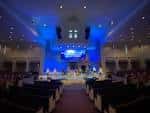 Interior del auditorio con iluminación azul y escenario