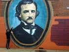 Mural artístico en pared de ladrillo con retrato ovalado de Edgar Allan Poe