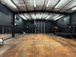 Interior del estudio de grabación con suelo de madera y paredes oscuras