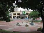 Plaza central del parque con fuentes y áreas verdes para celebraciones