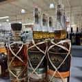 Exhibición de botellas de bourbon envueltas con cuerda en el interior de la tienda