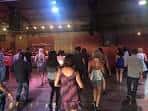 Interior del local durante un evento social con personas bailando