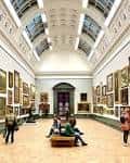 Galería principal del Tate Britain con obras de arte en las paredes y techo acristalado