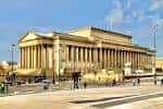 Vista exterior del St George's Hall con su imponente fachada neoclásica y columnas jónicas bajo un cielo azul
