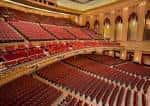 Vista panorámica del interior del auditorio con butacas rojas y arquitectura clásica